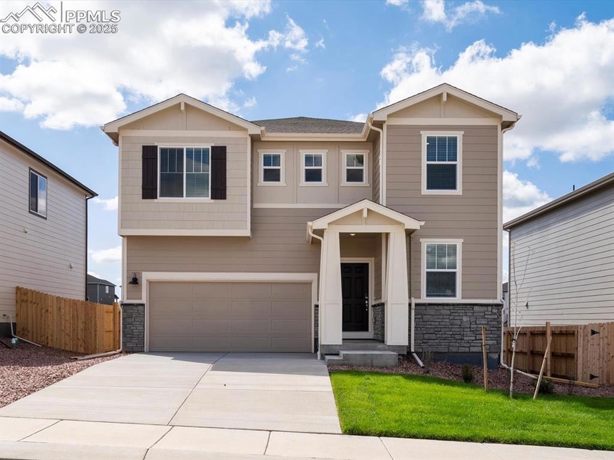 Craftsman-style home featuring stone siding, a garage, and driveway