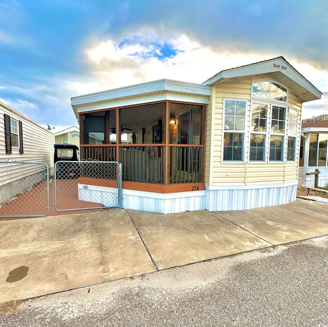 front view of house with large, screened porch and fence.