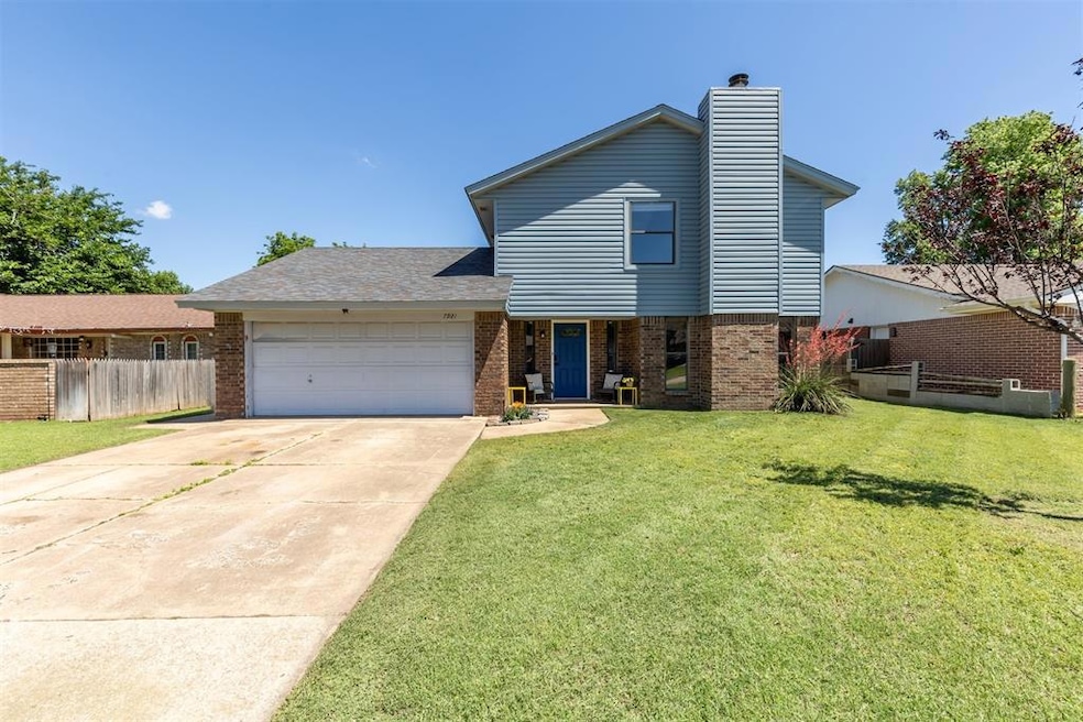 View of front of home featuring brick siding, a garage, driveway, and a chimney
