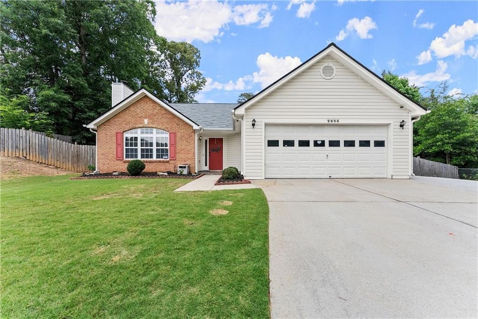 Ranch-style home featuring concrete driveway, a garage, brick siding, and a chimney