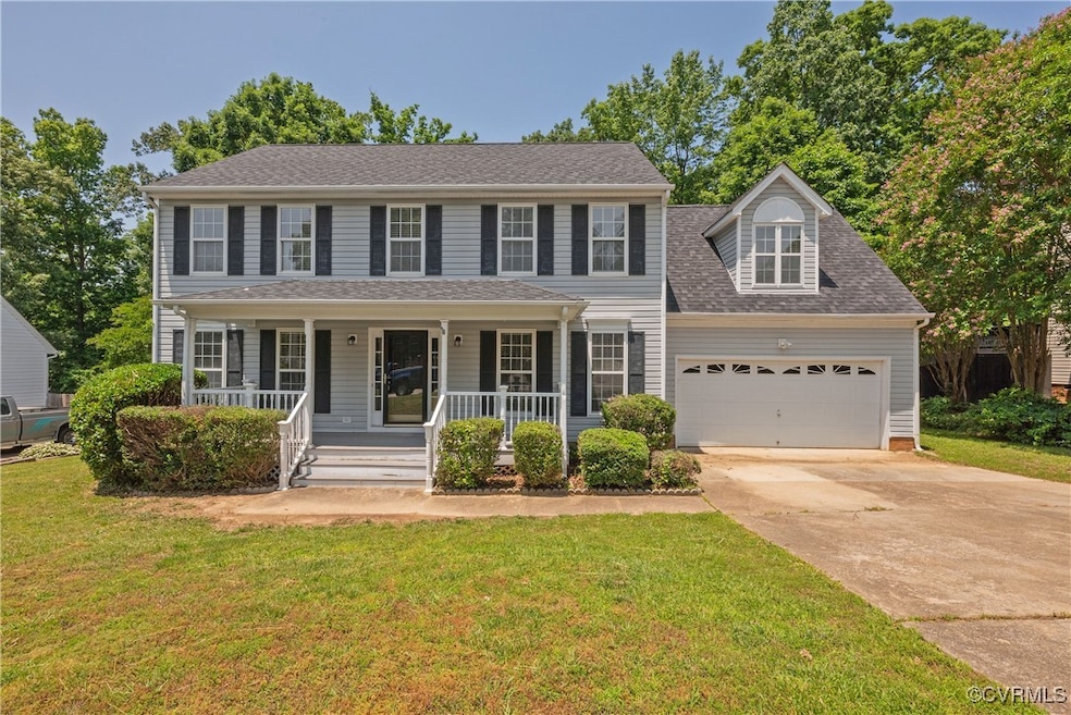 Colonial home with a garage, concrete driveway, co