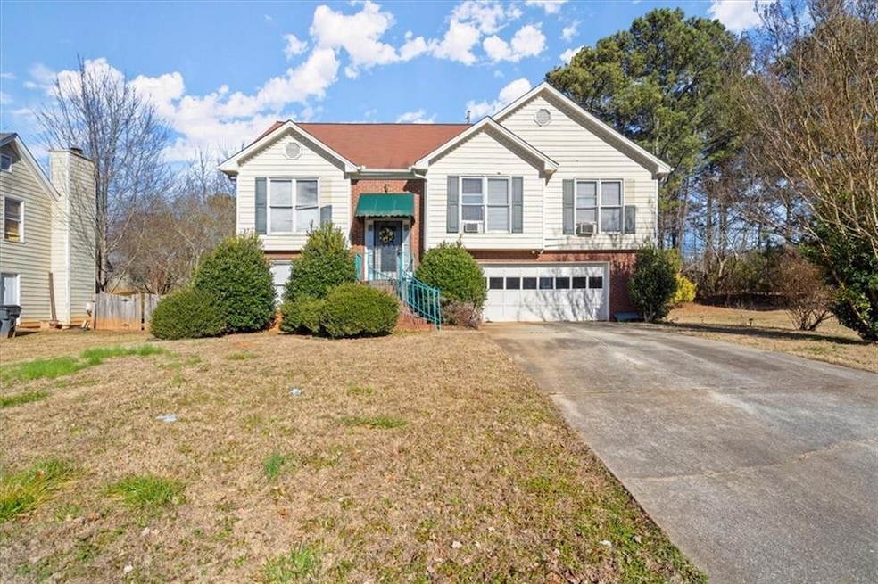 Split foyer home featuring a front lawn and a gara