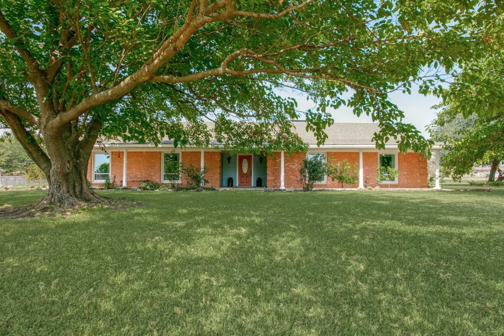 Large Trees and a large front porch grace the entry to this home