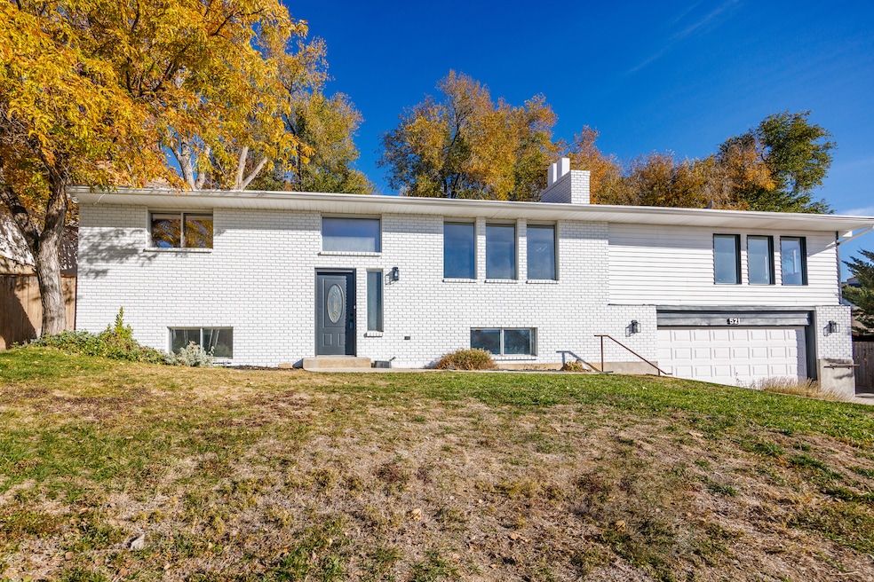 View of front of property featuring a chimney, brick siding, and a garage