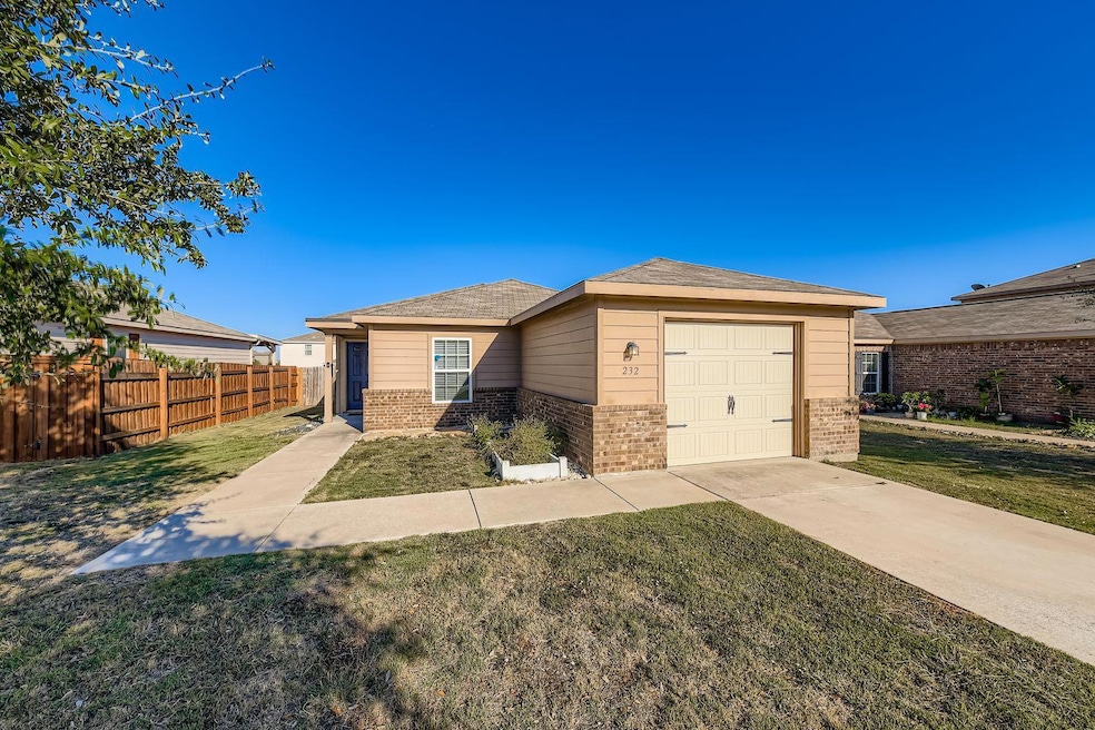 View of front of property featuring brick siding, concrete driveway, and a shingled roof