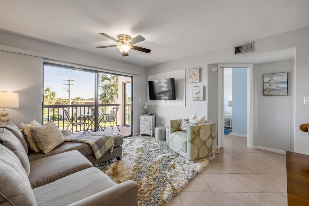 Living area featuring light tile patterned floors and ceiling fan