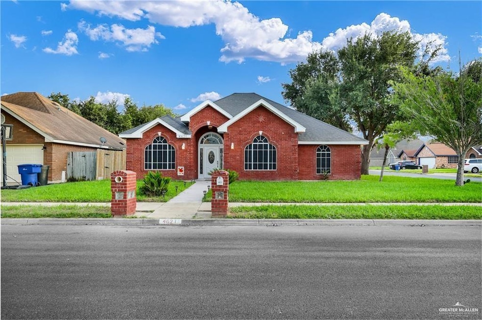 View of front of property featuring brick siding, a front lawn, and a garage