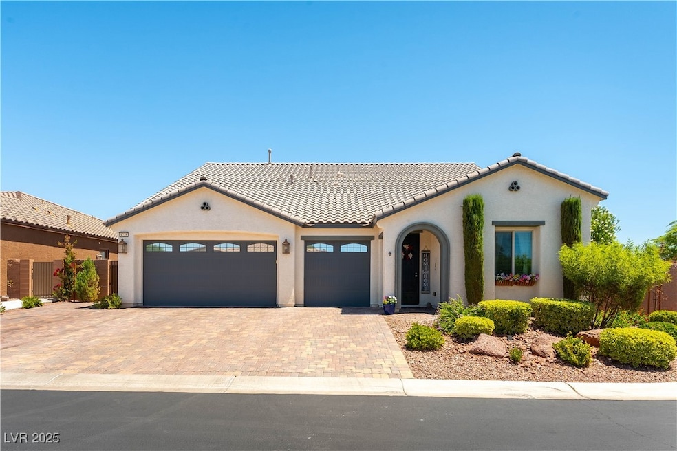 Mediterranean / spanish home with decorative driveway, a garage, stucco siding, and a tile roof
