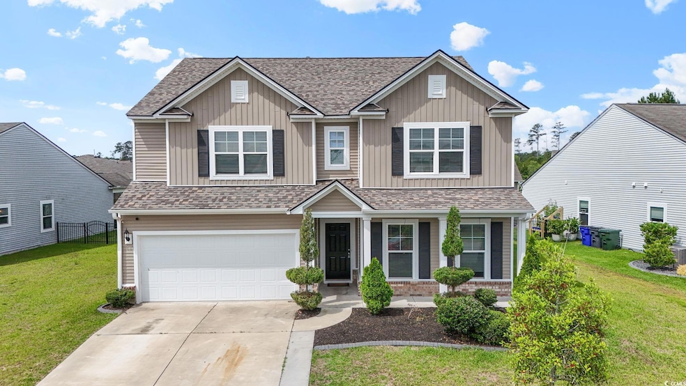 View of front facade featuring an attached garage, driveway, board and batten siding, and a shingled roof