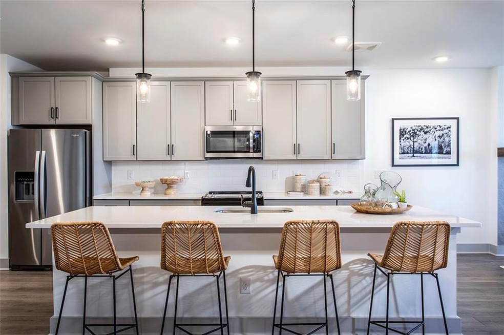 Kitchen featuring gray cabinets, hanging light fix