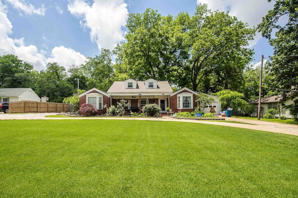 View of front of house featuring covered porch, brick siding, and driveway