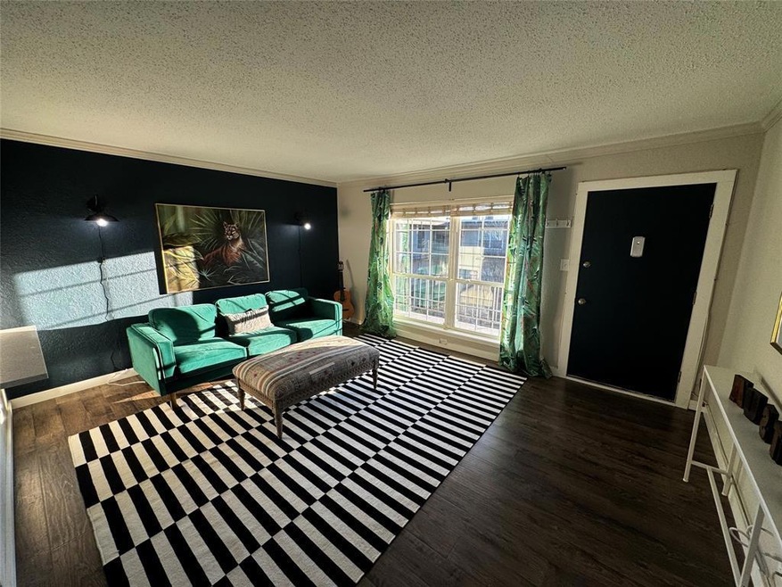 Living area with crown molding, a textured ceilin