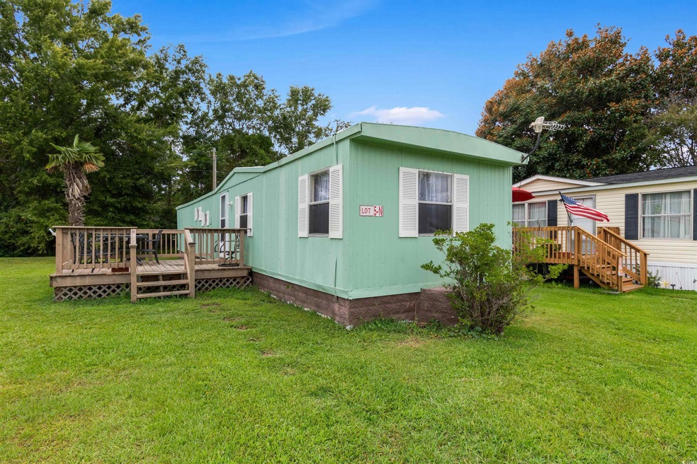View of home's exterior with a wooden deck and a l