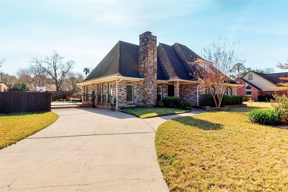 The extra long driveway leads to an automatic gate, extra parking, the garage is to the left, and the pool is on the right.
