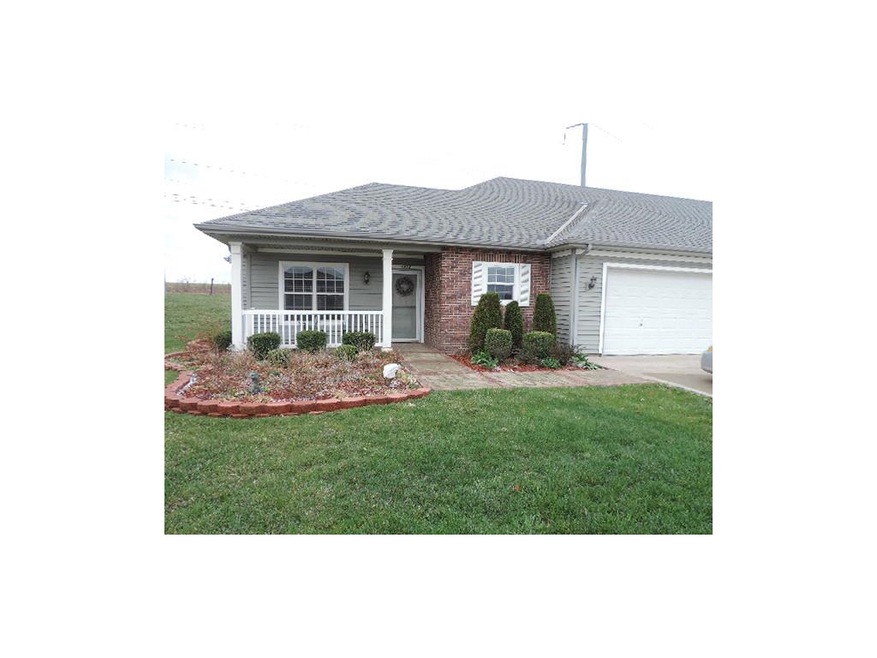 Front of the home. Porch and stone sidewalk.