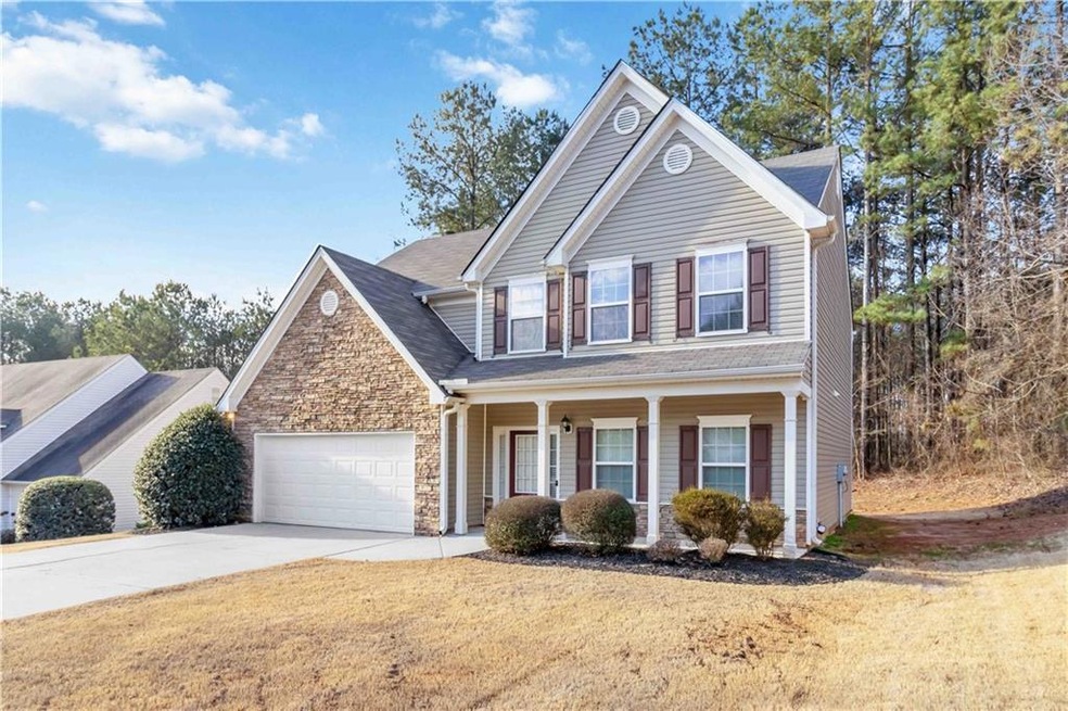 Traditional home featuring a porch, a garage, ston