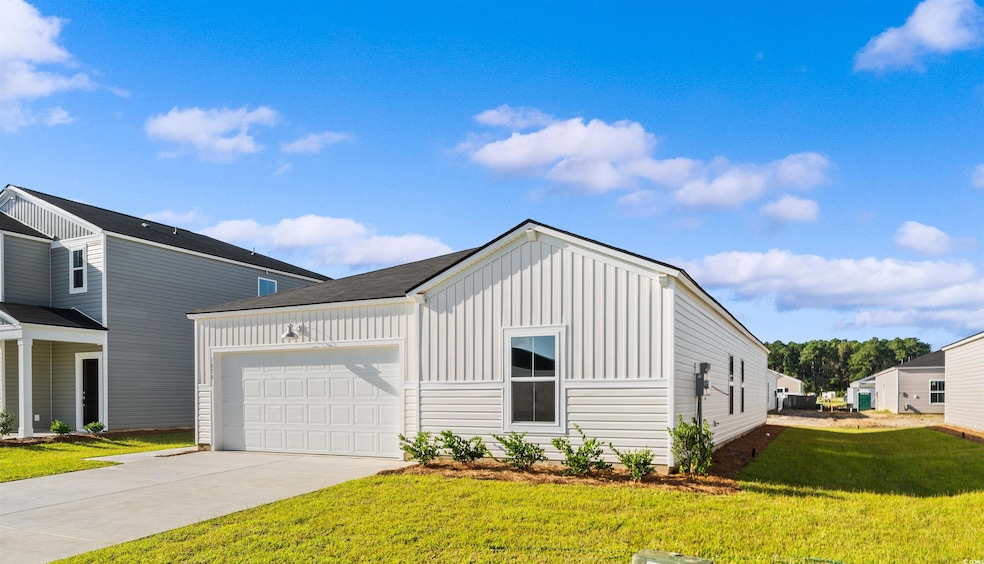 View of front of house featuring board and batten siding, a garage, driveway, and a front yard