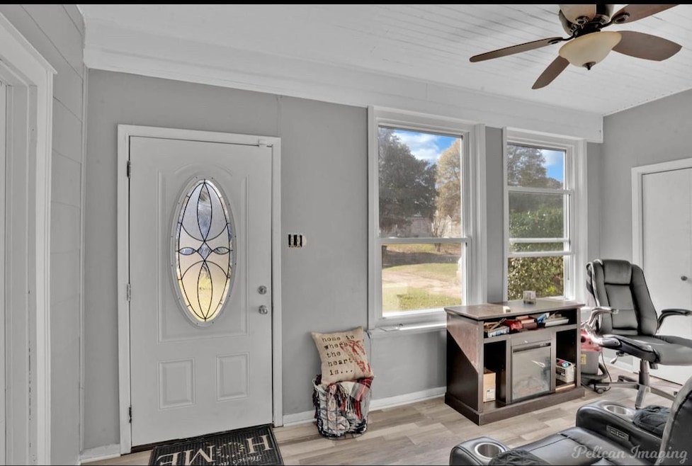 Foyer entrance with ceiling fan and light hardwood