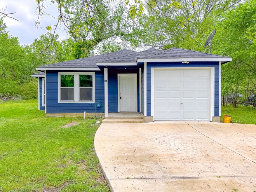 Ranch-style home featuring a shingled roof, driveway, a front yard, and a garage