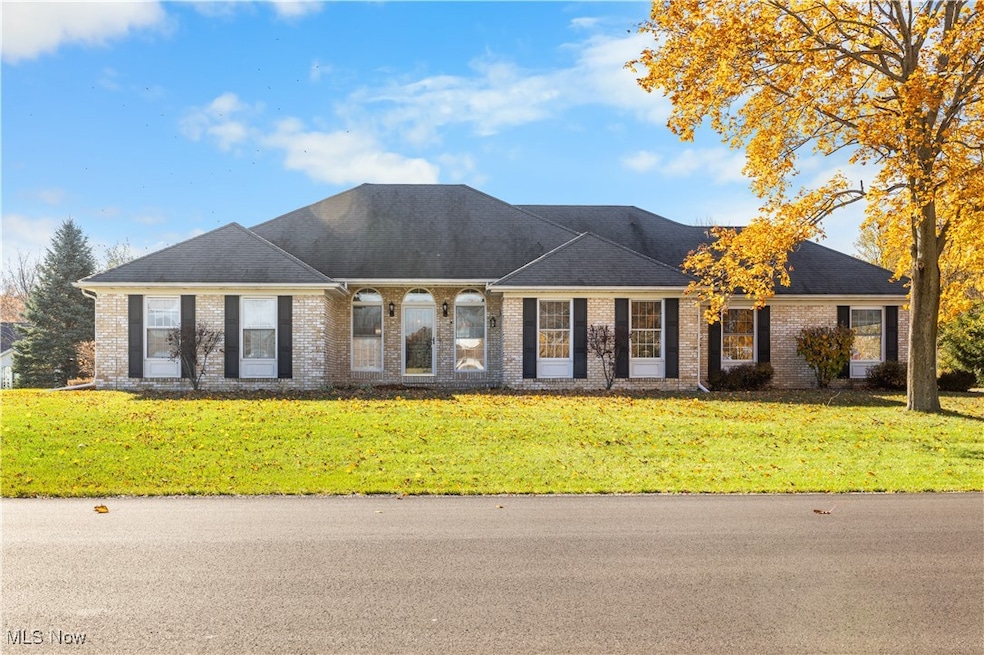 View of front of house featuring brick siding, a front lawn, and a shingled roof