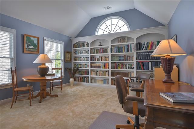 Large upstairs library with built-in book shelves measures 12 x 14 with adjoining bath and vaulted ceiling and transom window.