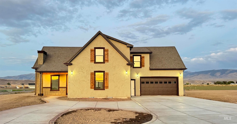 View of front of property featuring a mountain view, roof with shingles, concrete driveway, stucco siding, and a garage