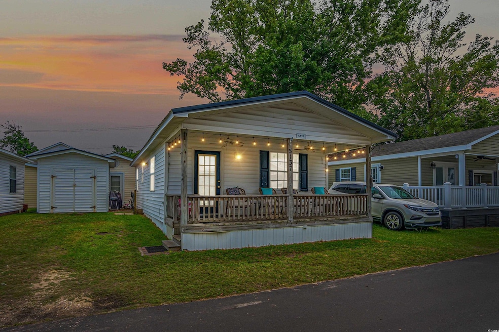 View of front of home with a porch, a lawn, and a 