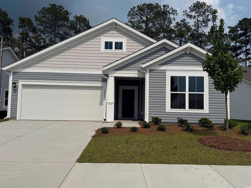 View of front of property with concrete driveway, a garage, and a front lawn