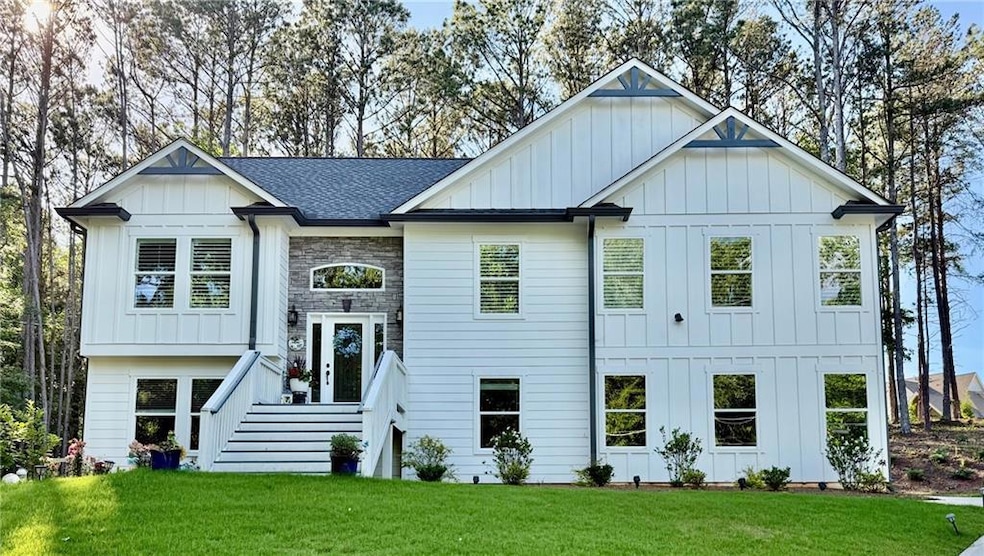 View of front of property with board and batten siding and a front lawn