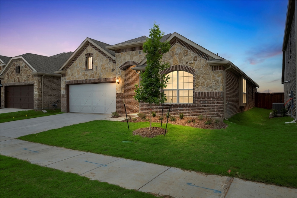 French country inspired facade featuring stone siding, driveway, and brick siding