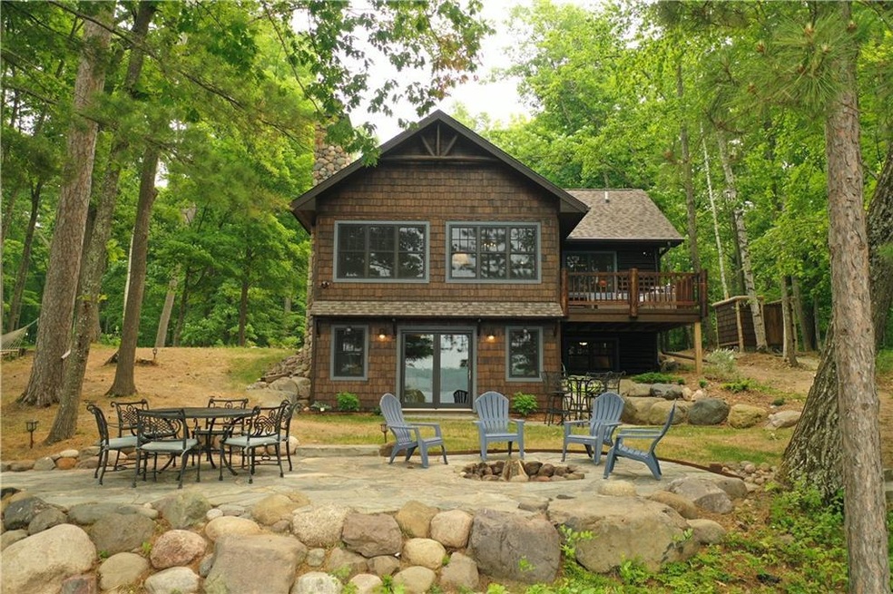 Welcome to the beautiful log cabin, overlooking the stone patio and lake with sandy beach!