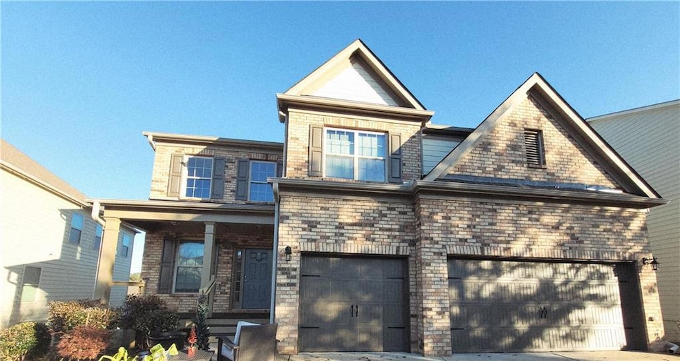 View of front of property with concrete driveway, a garage, and brick siding