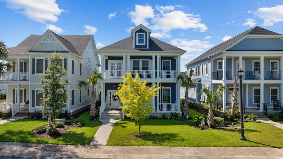 View of front of home featuring a balcony, covered porch, a front lawn, french doors, and roof with shingles