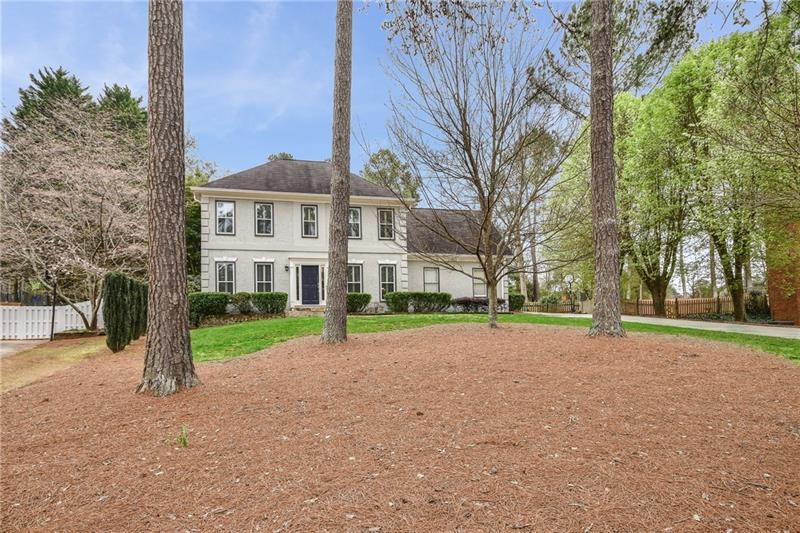 Stunning large FLAT front yard for this HARDCOAT stucco home with newer windows and plantation shutters!