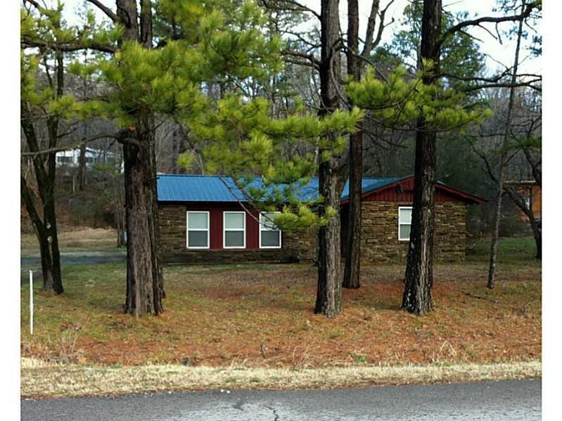 Exterior Front. Pines line the road.