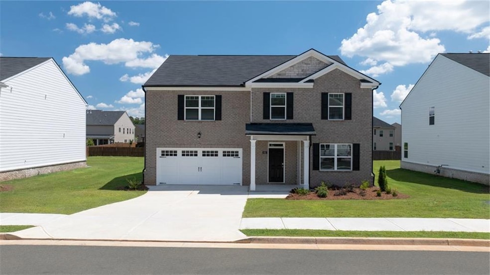 Traditional-style home featuring a front yard, a g