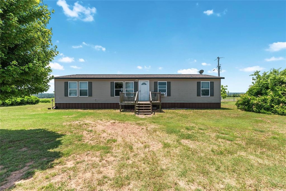 Manufactured / mobile home featuring a front lawn and a wooden deck