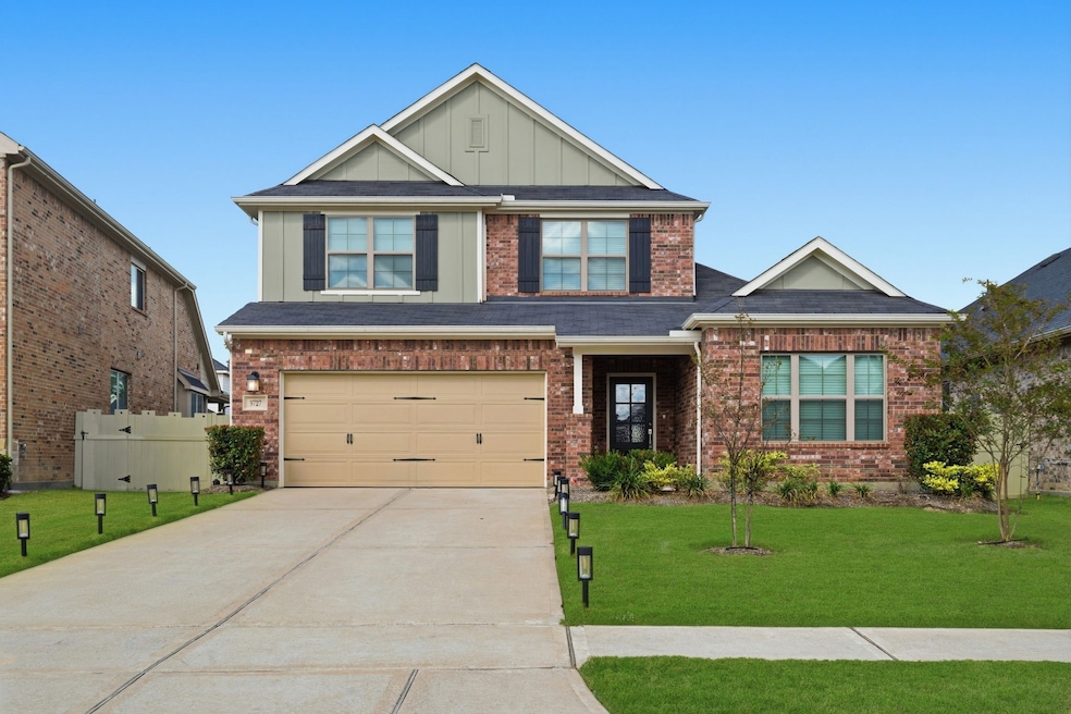 This is a two-story brick home with a neatly maintained front yard and a two-car garage. The house features a welcoming front porch.