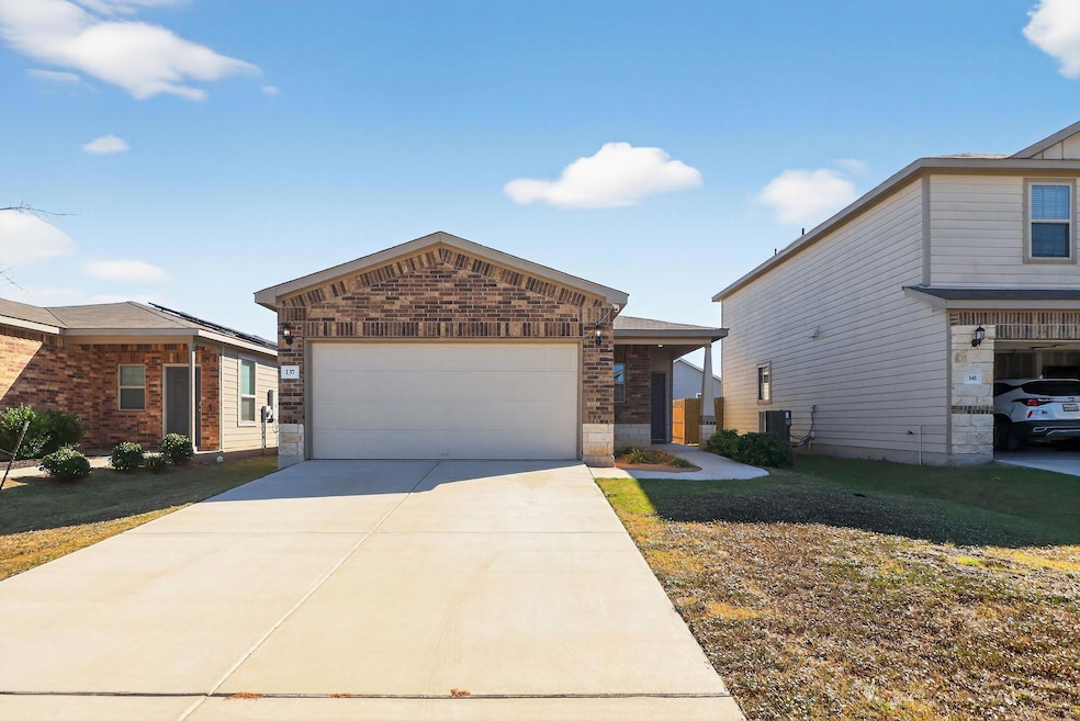 View of front of home with brick siding, concrete driveway, a garage, and a front yard
