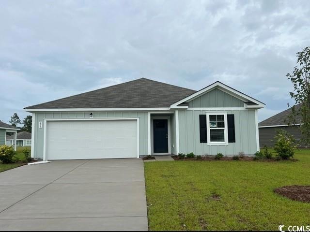 Ranch-style home featuring a front lawn and a gara