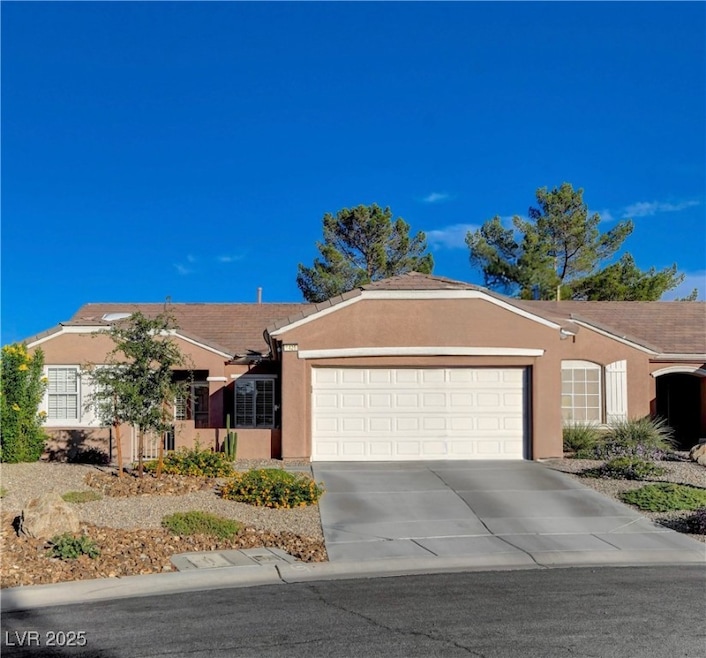Ranch-style house featuring stucco siding, driveway, and a garage