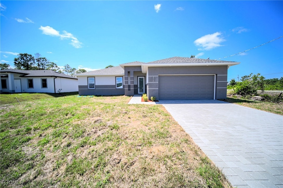 Prairie-style house with stucco siding, decorative driveway, and an attached garage
