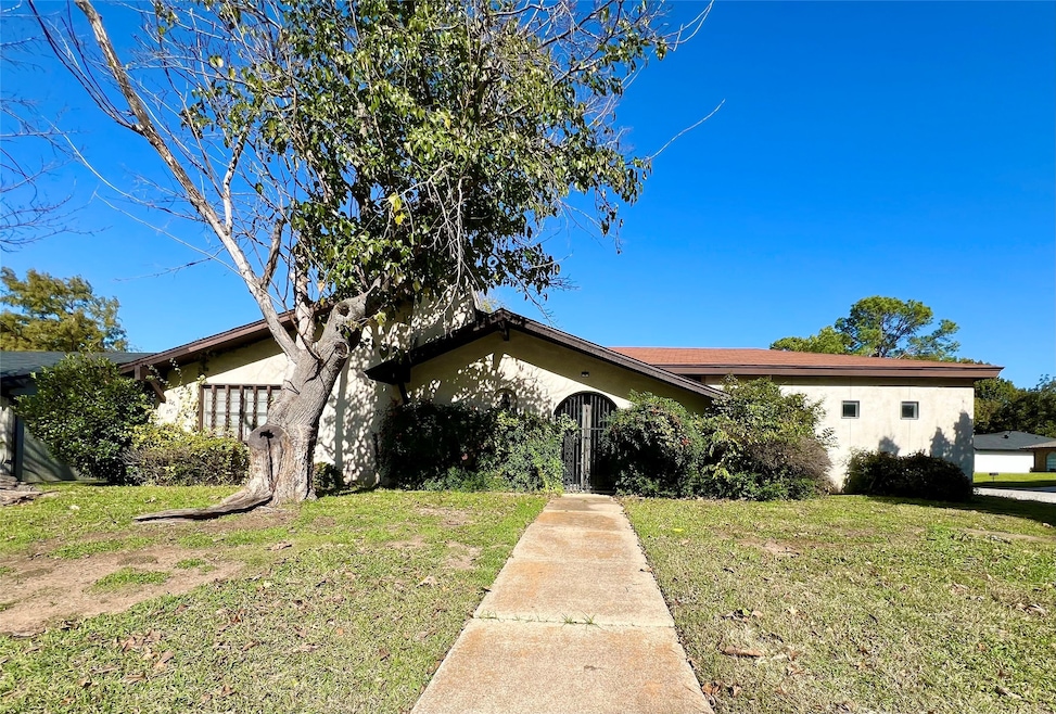 View of front of house featuring stucco siding, a front lawn, and a gate