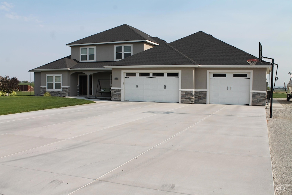 View of front of house featuring stucco, stone, and an attached garage.