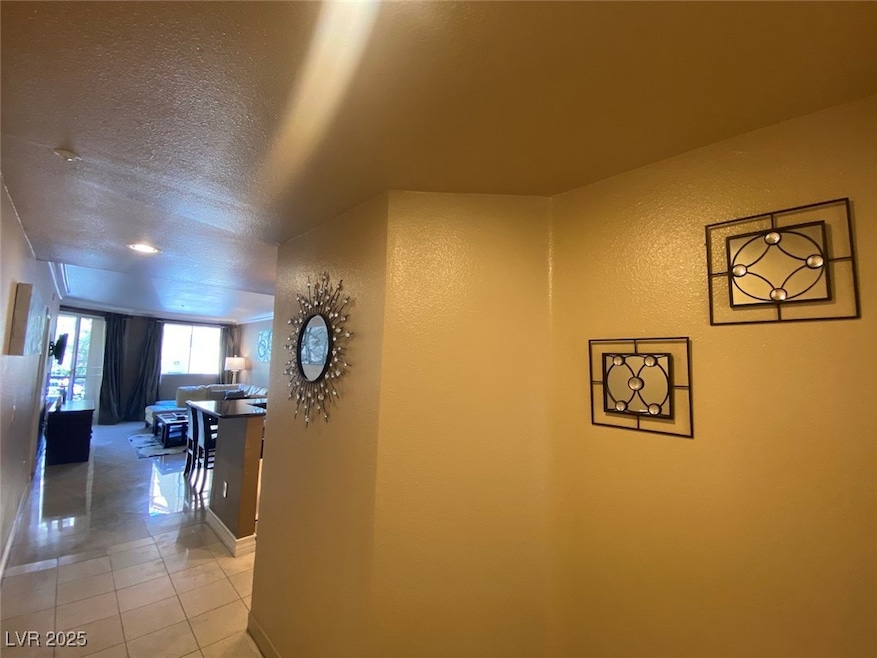 Hall with light tile patterned floors, baseboards,