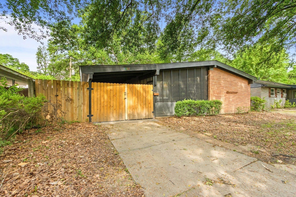 View of outbuilding featuring concrete driveway and a sunroom