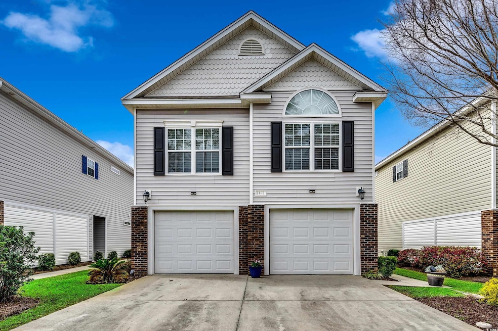 Traditional-style home with a garage, concrete driveway, and brick siding