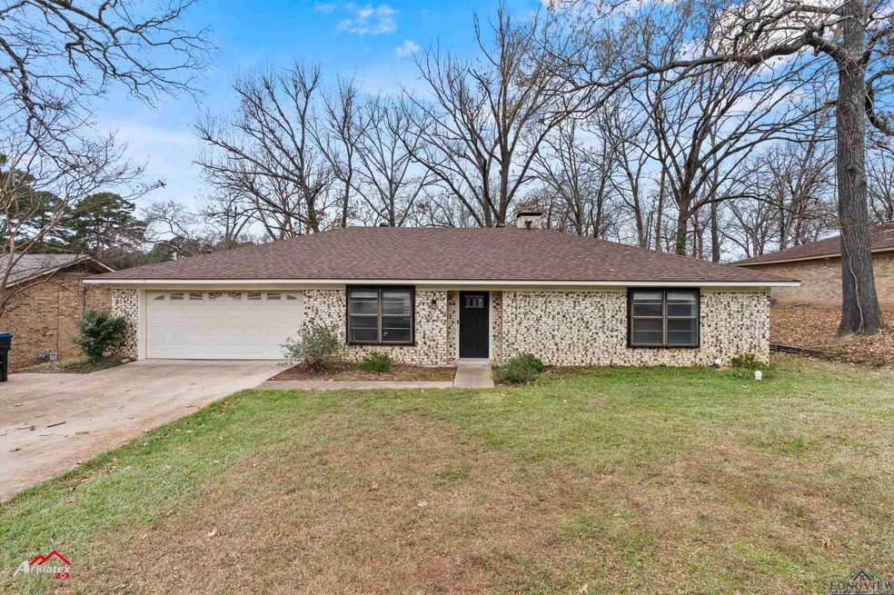 Ranch-style home featuring a front yard and a gara