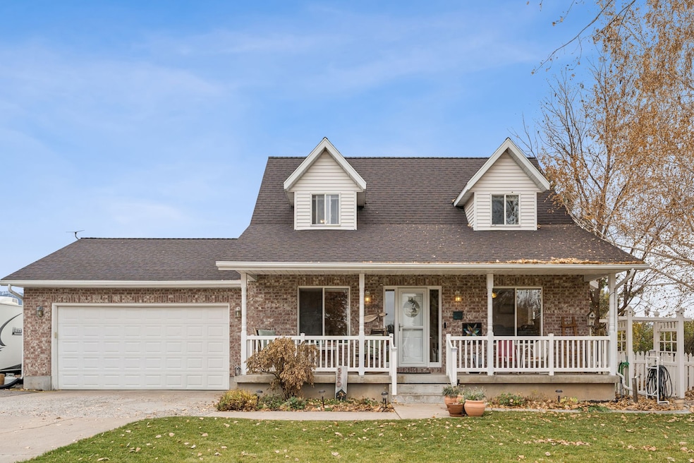 View of front of home with a porch, a shingled roof, brick siding, and a front yard