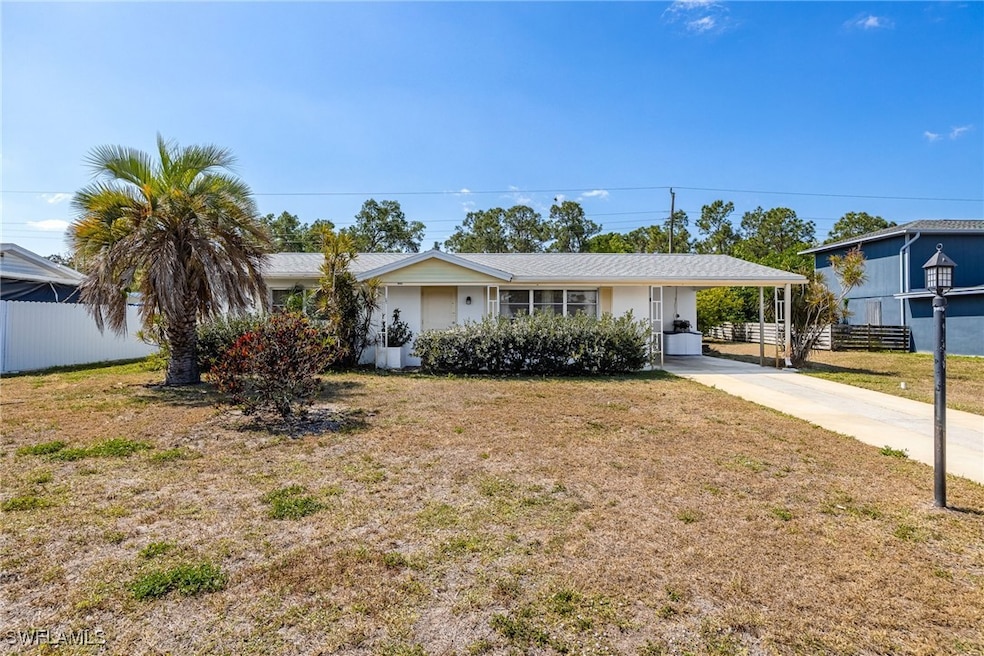 Ranch-style house with fence, a front lawn, a carp